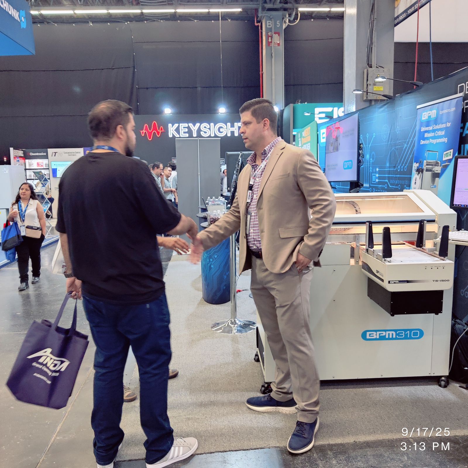 Handshake at BPM booth beside the BPM310 Hybrid during SMTA Guadalajara